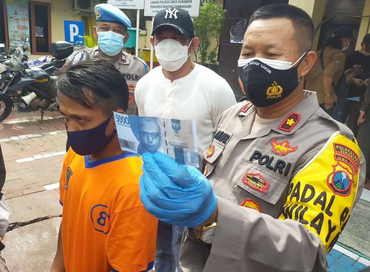 Tersangka dan barang bukti uang palsu yang diamankan Polsek Tambaksari. (Foto:  Farizal Tito/jatimnow.com)
