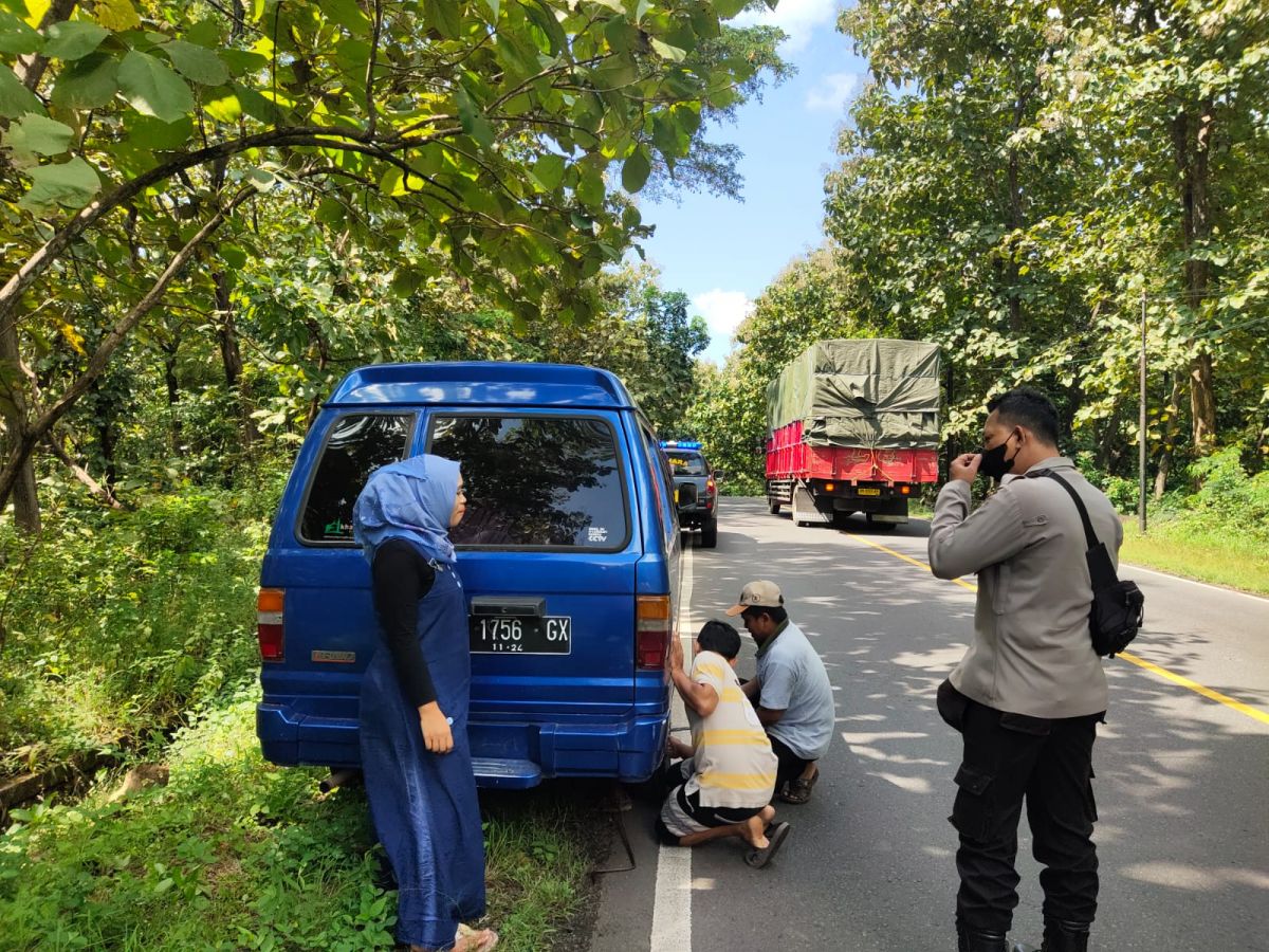 Polsek Banyuputih membantu pengendara yang mengalami ban bocor. (Foto: Humas Polres Situbondo for jatimnow.com)