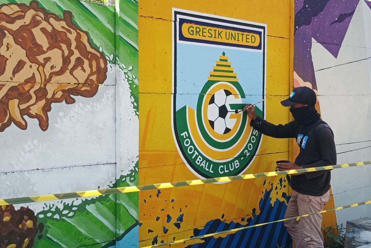 Earl, salah satu seniman mural saat melukis logo Gresik United (Foto: Sahlul Fahmi/jatimnow.com)