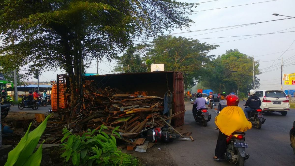 Truk bermuatan besi tua terguling di pertigaan lampu merah Klagen, Sidoarjo. (Foto: Polsek Krian/jatimnow.com)