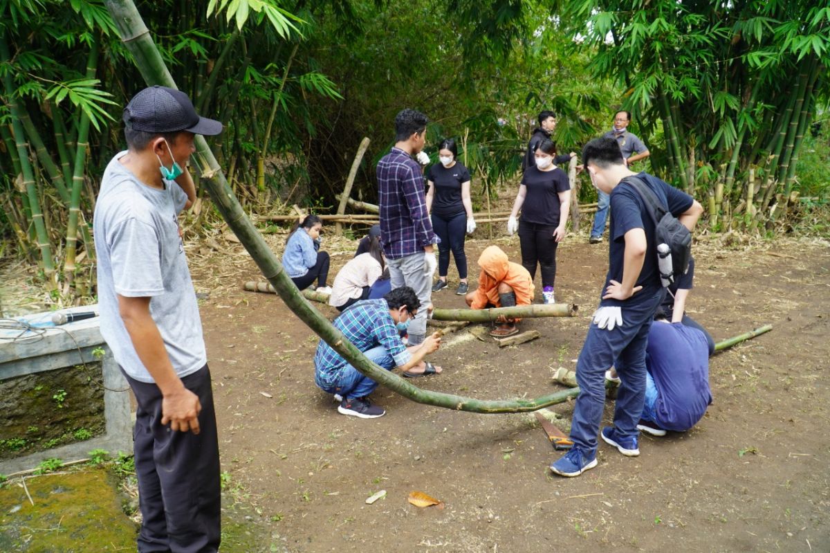 Sahabat Bambu dan para mahasiswa Arsitektur UKP saat mencoba belajar membuat bangunan bahan bambu dengan teknik lengkung. (Humas UK Petra for jatimnow.com)