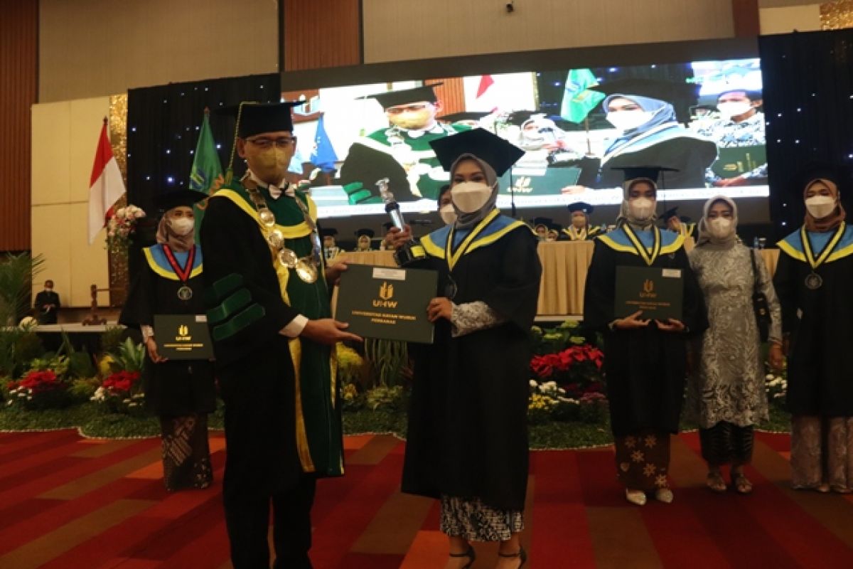 Rektor Universitas Hayam Wuruk Perbanas Dr Yudi Sutarso memberikan penghargaan pada wisudawan terbaik Febriyani Sarwindah. (Foto: Humas Universitas Hayam Wuruk Perbanas/jatimnow.com)