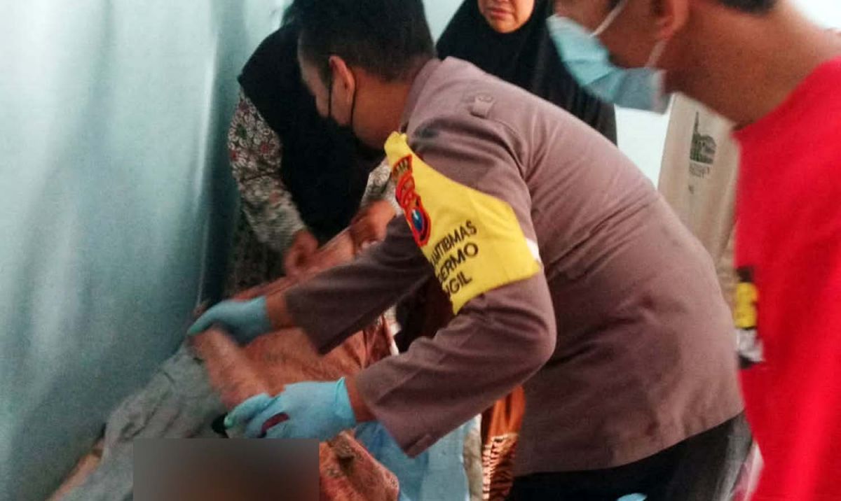 Polisi mengecek bocah SD di Pasuruan yang tewas tenggelam (Foto: Polsek Bangil)