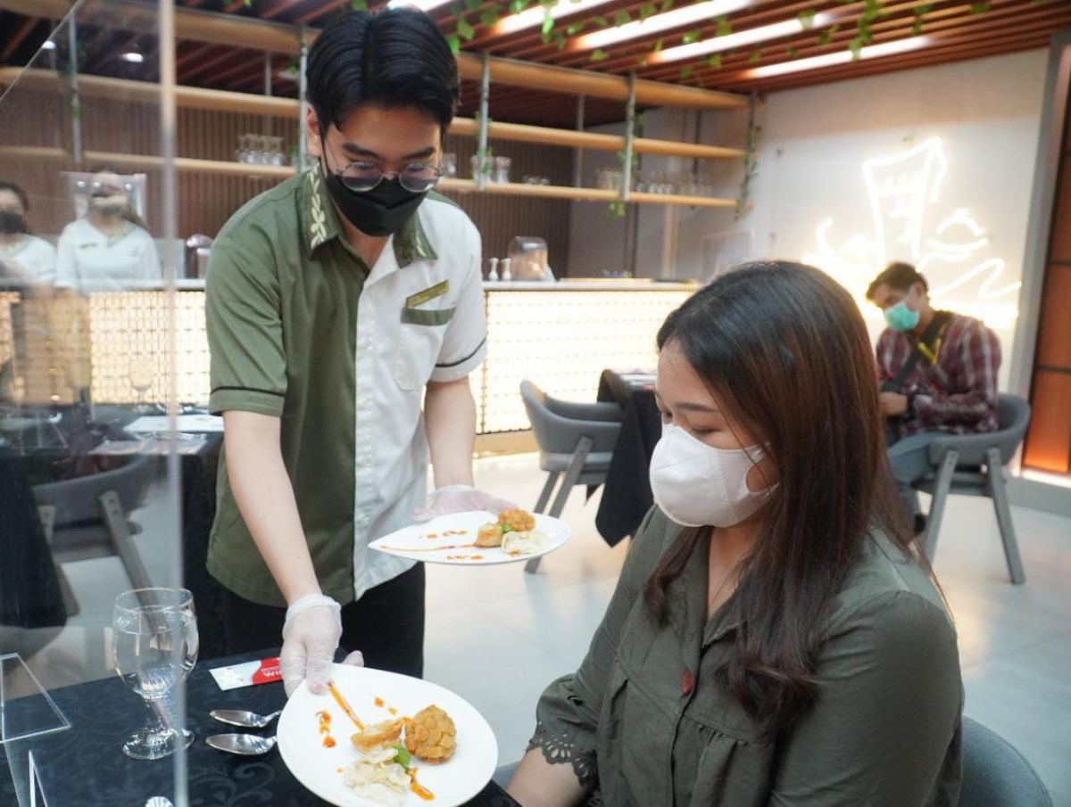 Seorang mahasiswa sedang menyajikan appetizer pada pengunjung. (Foto: Humas UK Petra/jatimnow.com)