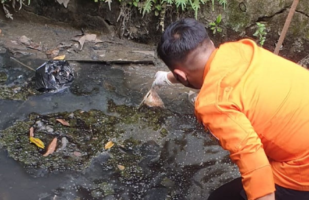 Petugas mengevakuasi jasad orok di saluran air Jalan Jemur Ngawinan, Wonocolo, Surabaya. (Foto: BPBD Surabaya for jatimnow.com).