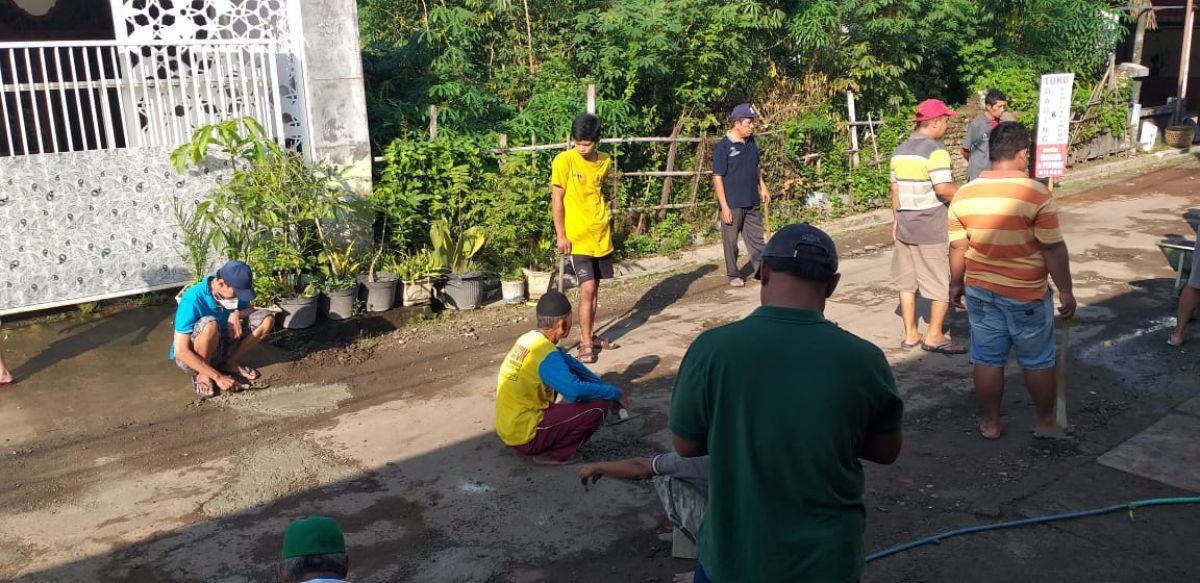 Warga Jalan Wilis, Kelurahan Banyudono perbaiki jalan yang rusak. (Foto: Dono for jatimnow.com)