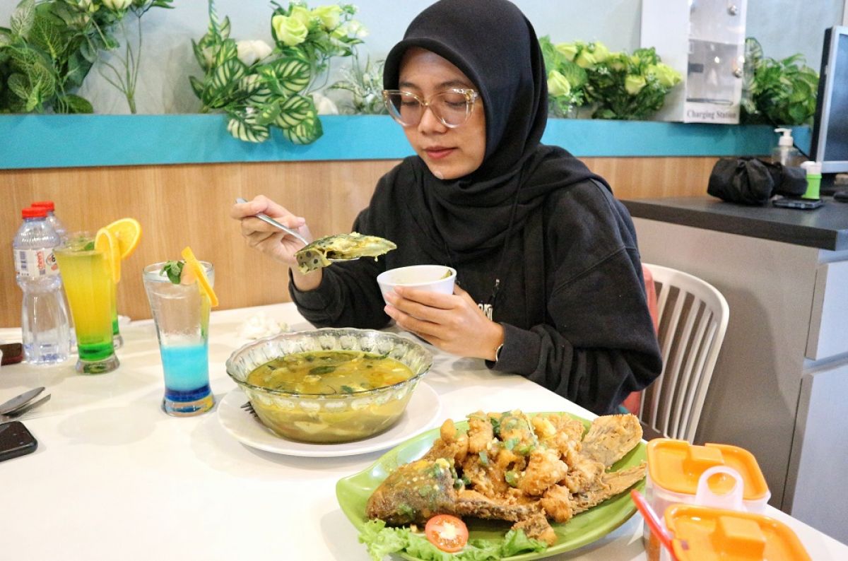 Pengunjung menikmati olaha gulai salmo ala Resto Bebek Joss Gandos. (Foto: Fajar Mujianto/jatimnow.com)