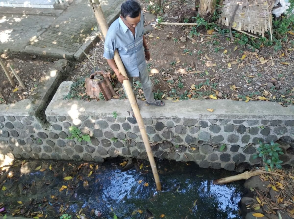 Saluran irigasi warga di sekitar gudang yang terbakar tecemar limbah solar (Foto: Humas Polres Bondowoso)