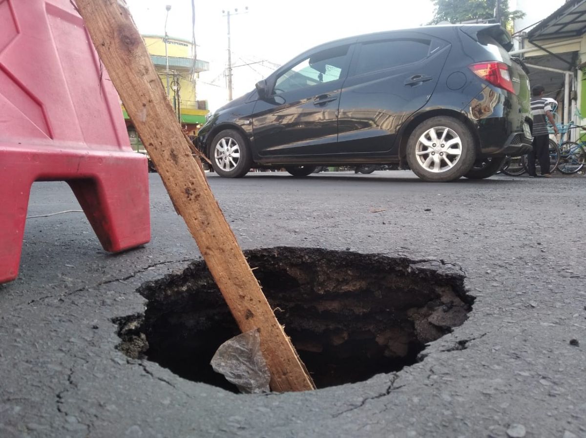 Jalan berlubang mirip sumur di Pertigaan Jalan Agus Salim Bondowoso (Foto: Dwi Kuntarto Aji/jatimnow.com)