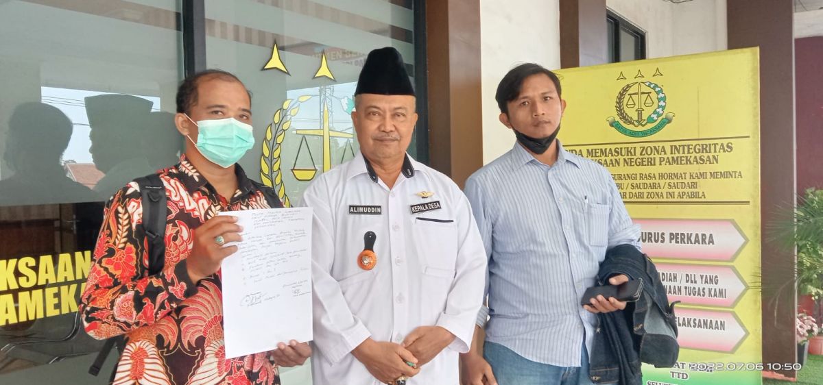 Kepala Desa Laden, Alimuddin (berpeci hitam) didampingi penasihat hukum saat melakukan laporan ke Kejari Pamekasan. (Foto: Fathor Rahman/jatimnow.com)