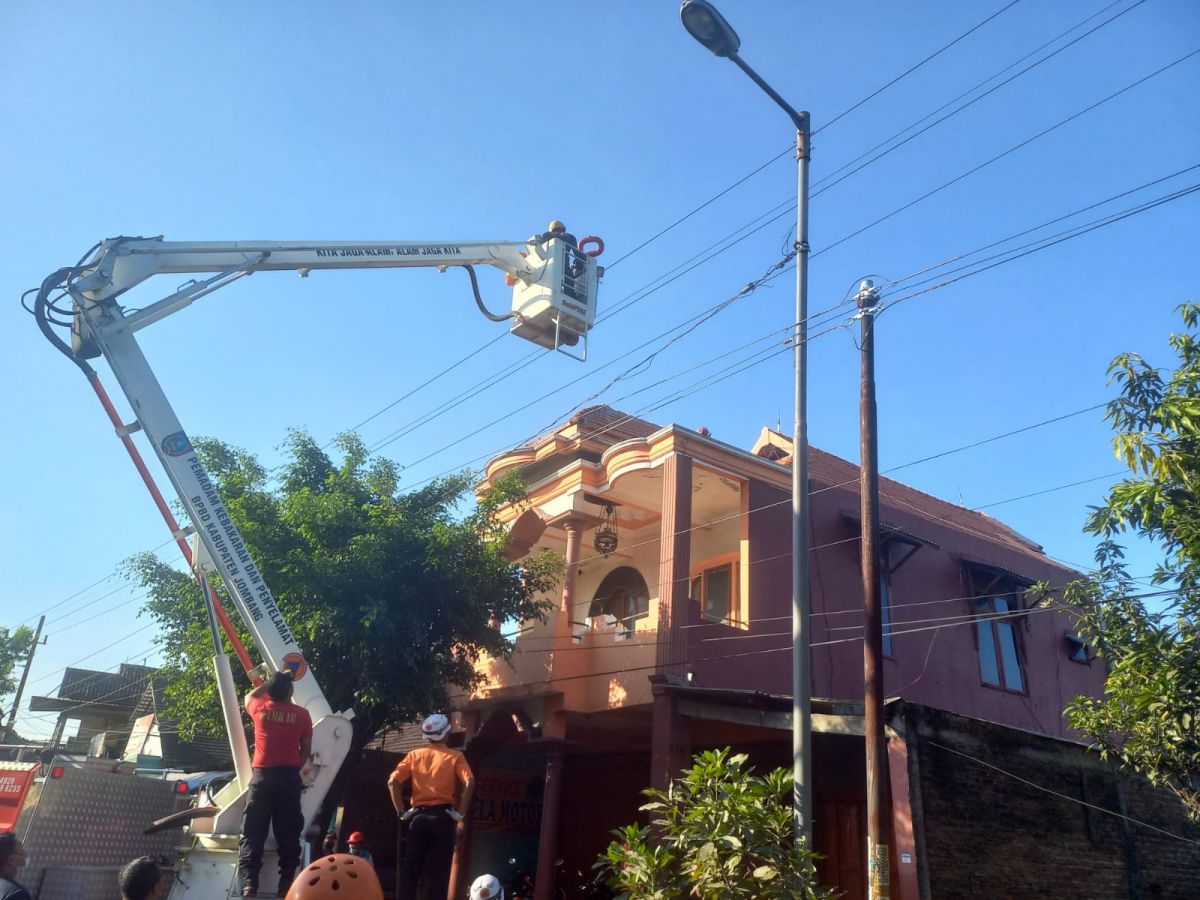 Tim Damkar BPBD Kabupaten Jombang mengevakuasi pekerja bangunan yang tersengat aliran listrik (Foto: Elok Aprianto/jatimnow.com)