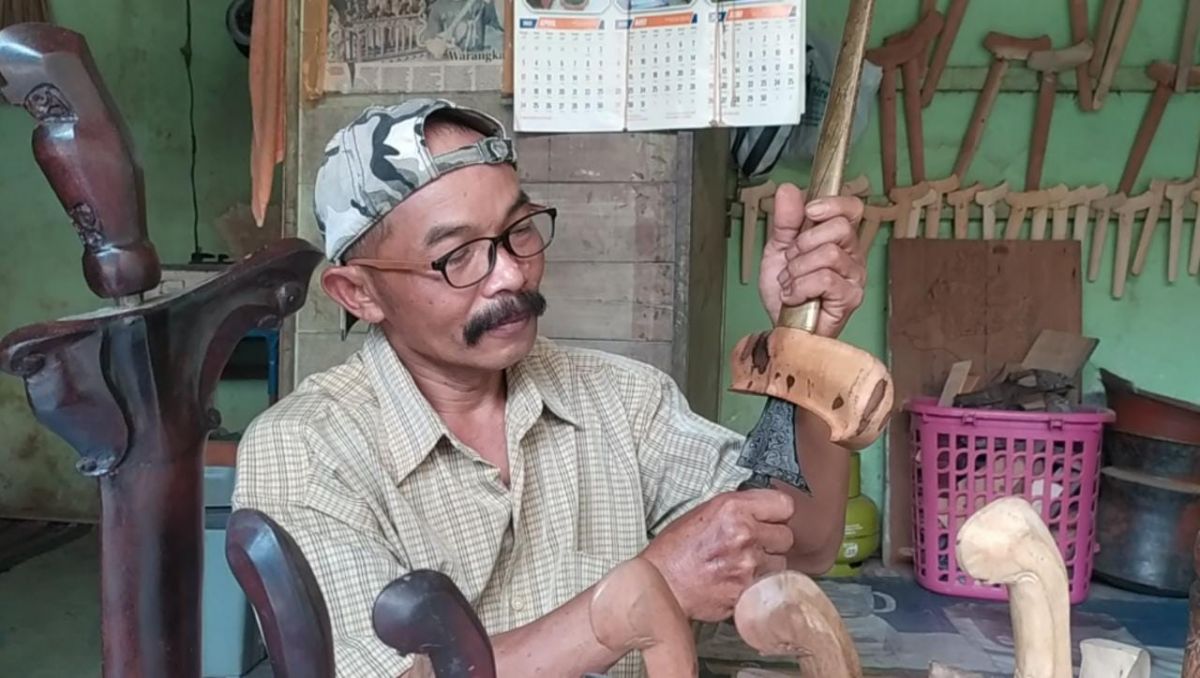 Sudahri (52) warga Desa Mojotrisno, Kecamatan Mojoagung, saat mencuci pusaka milik pelanggan.(Foto: Elok Aprianto)