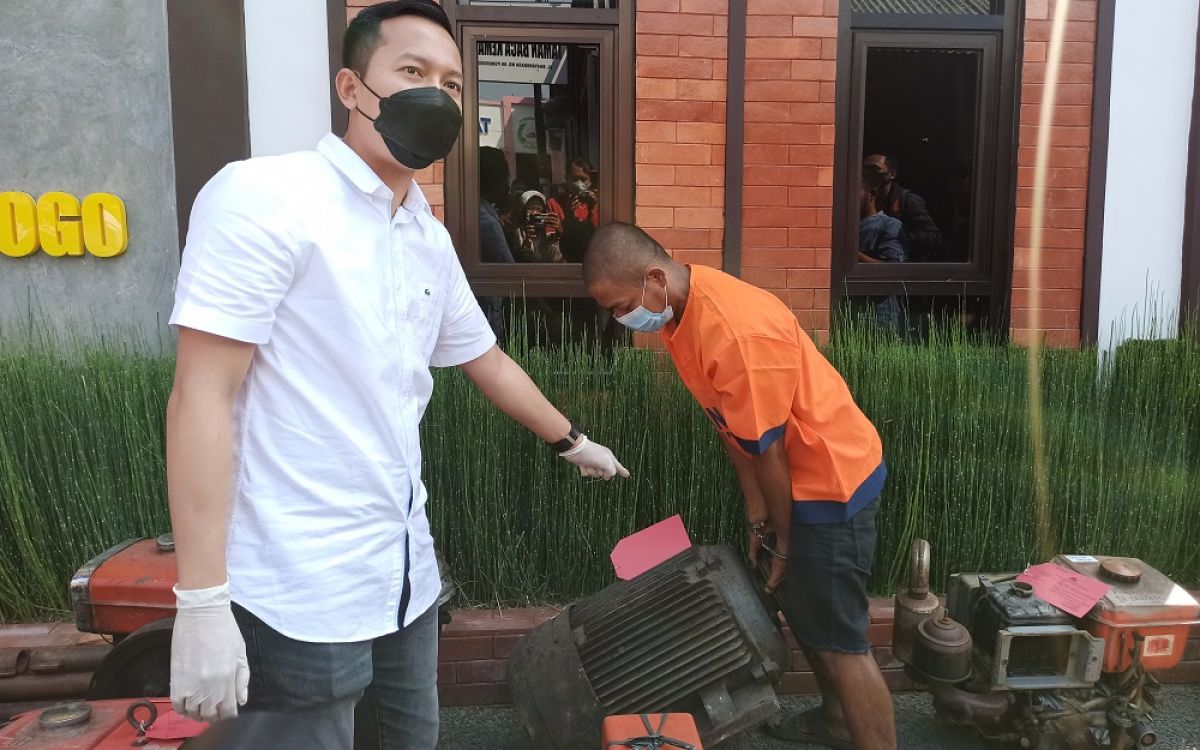 Jolodong mempraktikkan cara mengangkat hasil curiannya. (Foto: Mita Kusuma/jatimnow.com)