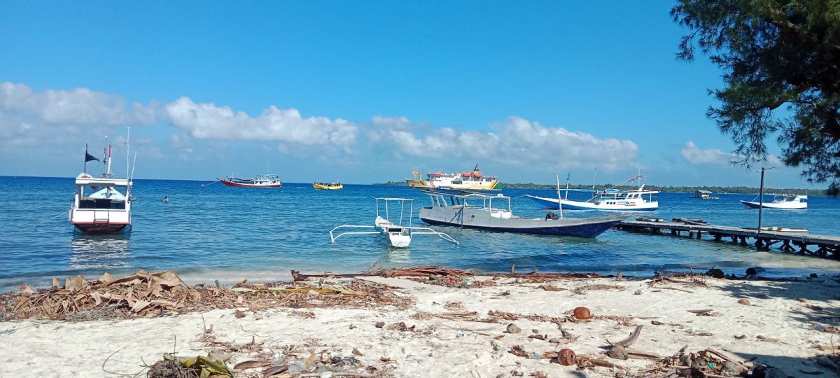 Kapal nelayan melakukan penjemputan penumpang KM Perintis di tengah laut di Desa Pagerungan Besar, Kecamatan Sapeken, Sumenep.(Foto: Dino for jatimnow.com)