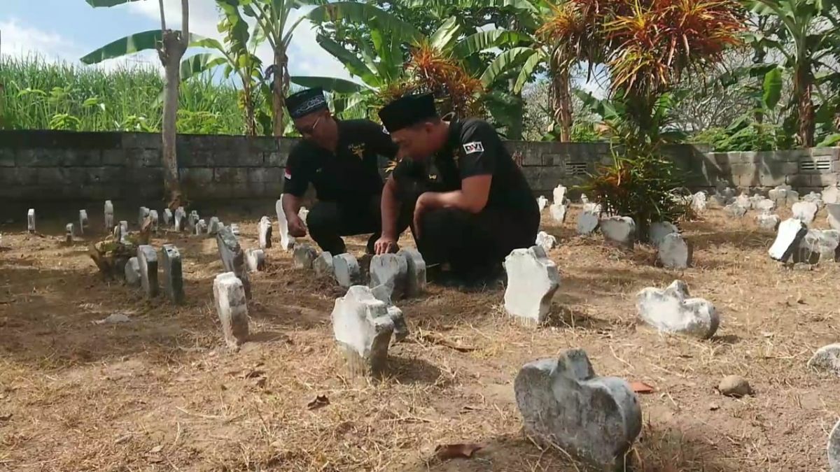 Petugas membersihkan kompleks makam tanpa identitas di Tulungagung. (Foto: Bramanta Pamungkas/jatimnow.com)