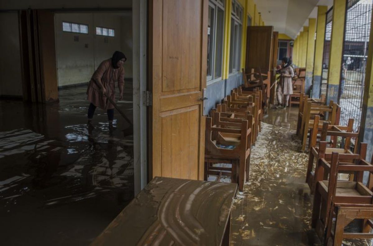 Dua orang guru membersihkan ruangan kelas yang terendam lumpur akibat banjir bandang Sungai Cimanuk di Sekolah PGRI Garut, Jawa Barat, Sabtu (16/7/2022).(Foto: ANTARA/Novrian Arbi via Republika)