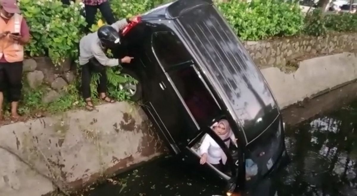 Wanita yang mengemudikan mobil tercebur sungai di Rungkut, Surabaya ditolong warga (Foto-foto: Pras for jatimnow.com)