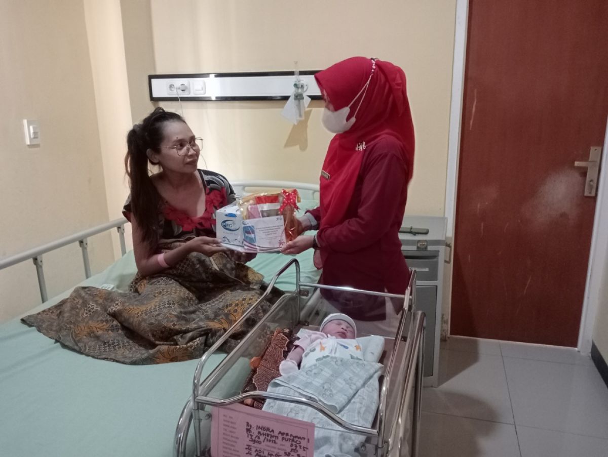Orang tua bayi Almira Sakila Zaneta saat menerima hadiah dari pihak RS PMC Jombang.(Foto: Elok Aprianto)