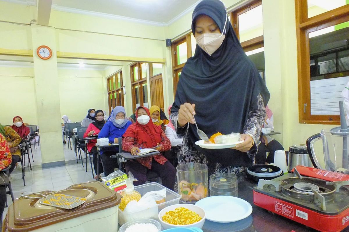 Hima Wirdhan dari Prodi D3 Kebidanan Unusa melatih kader kesehatan asal Wilayah Wonokromo membuat MPASI. (Foto: Kesar for jatimnow.com)