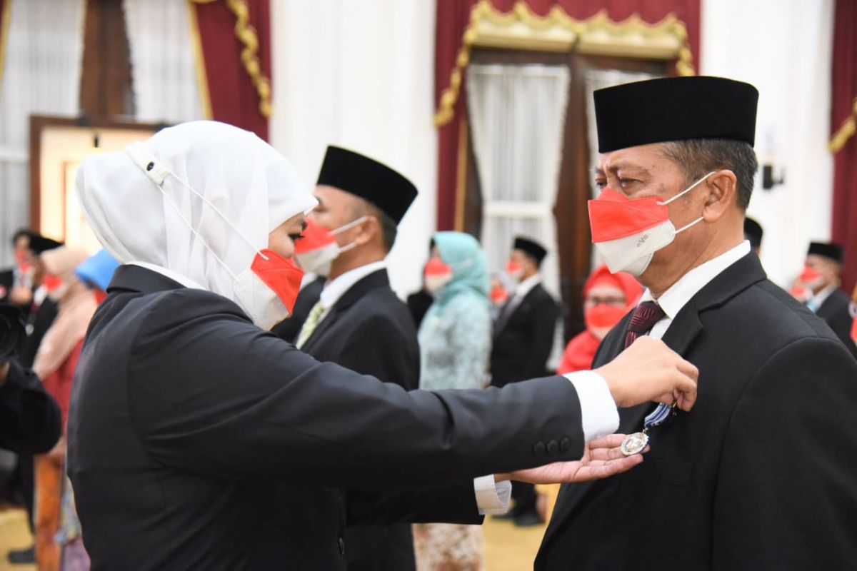 Penyematan tanda kehormatan Anugerah Satyalancana Karya Satya oleh Gubernur Khofifah. (Foto: Humas Pemprov Jatim for jatimnow.com)