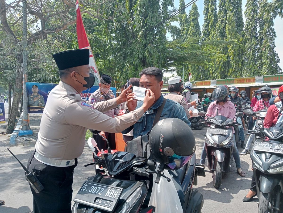 Satlantas Polres Jombang, membagikan nasi, air mineral dan masker pada pengguna jalan di depan Stadion Merdeka Jombang.(Foto-foto: Elok Aprianto/jatimnow.com)