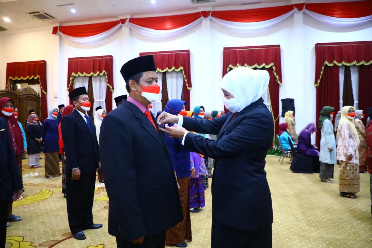 Gubernur Jatim Khofifah Indar Parawansa menyematkan Satyalancana Karya Satya kepada 215 guru SMA dan SMK.(Foto: Humas Pemprov Jatim)