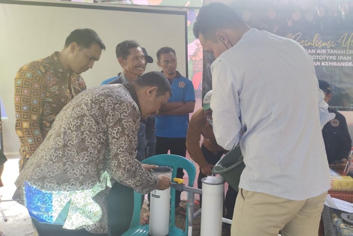 Unisla dan warga Desa Doyomulyo saat simulasi pengolahan air tanah menjadi AMDK. (Foto: Adyad Ammy/jatimnow.com)