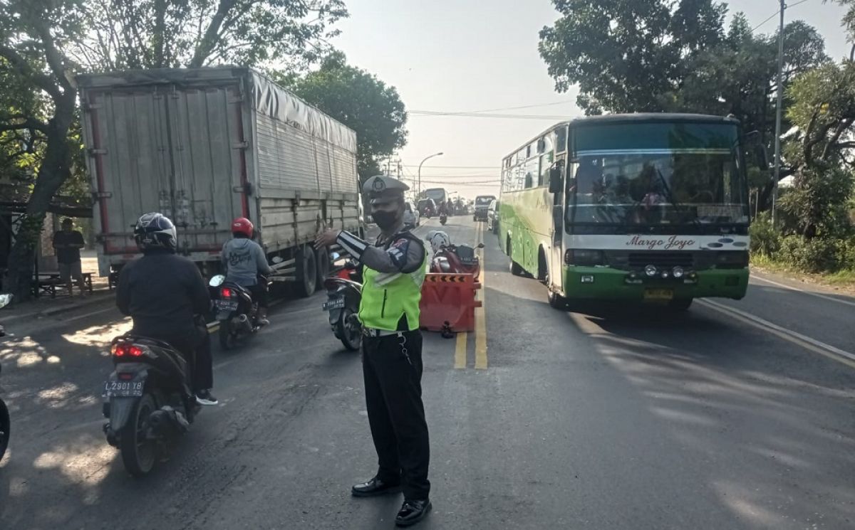 Polantas Polres Lamongan saat mengamankan jalur jembatan Ngaglik 1 di Lamongan yang akan diperbaiki. (Foto: Adyad Ammy Iffansah/jatimnow.com)