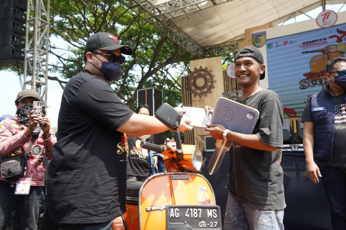 Mas Dhito menyerahkan doorprize utama berupa motor Vespa ke salah satu scooterist saat Panjalu Scooter Fest. (Foto: Humas Pemkab Kediri/jatimnow.com)