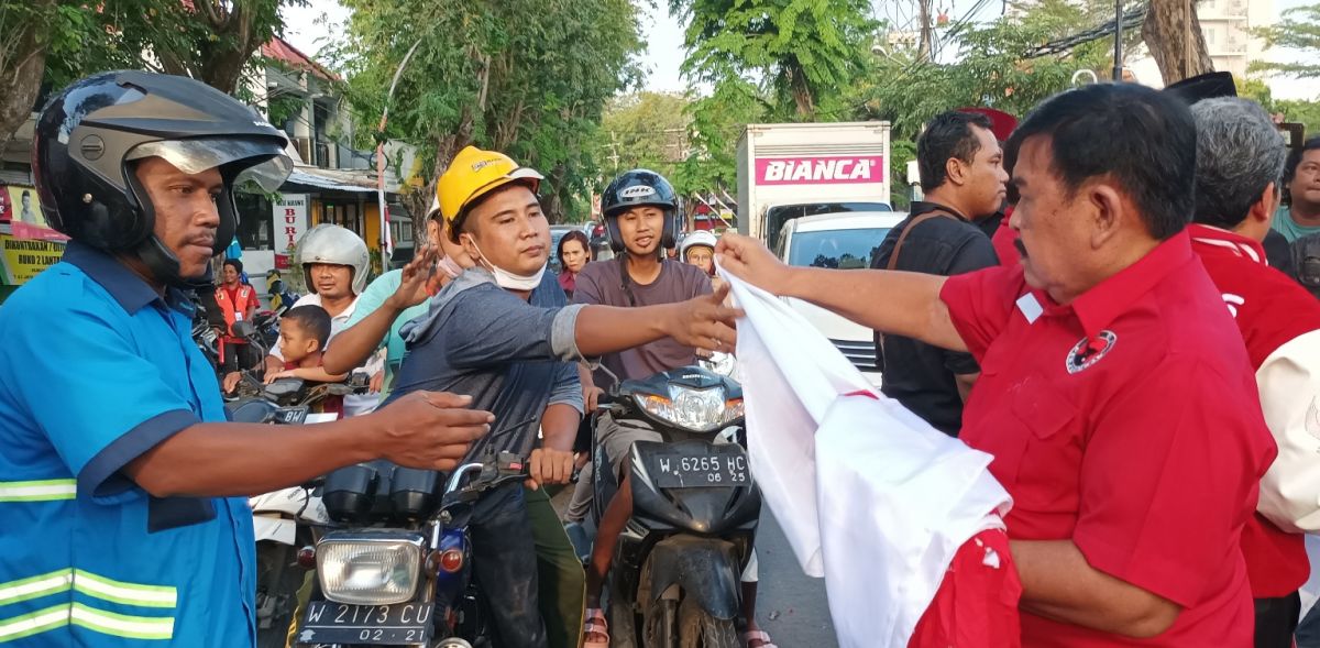 Pengurus PDI Perjuangan Kabupaten Gresik saat membagikan bendera merah putih.(Foto: Sahlul Fahmi/jatimnow.com)