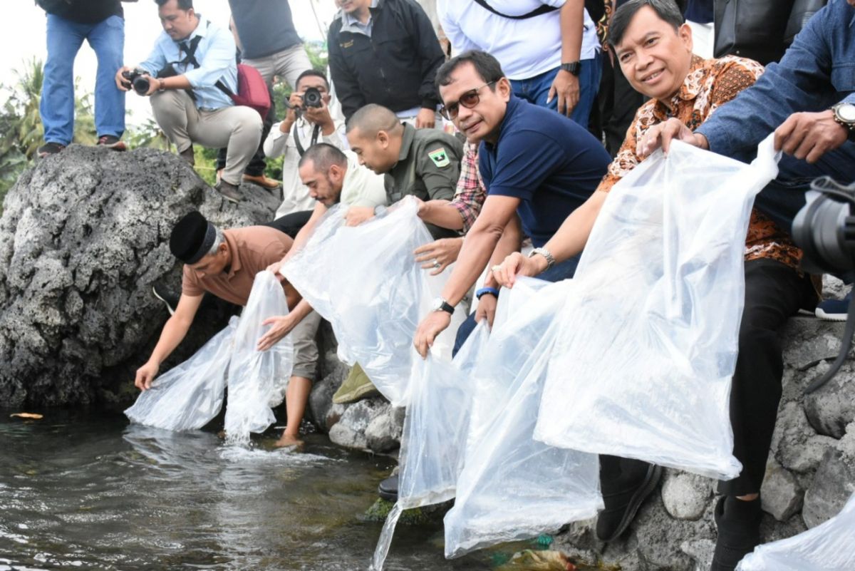 Direktur Utama SIG Donny Arsal (berkacamata) melepas ikan bilih di Danau SIngkarak, Sumatra Barat, Sabtu (30/7).(Foto: Dok. Humas SIG)