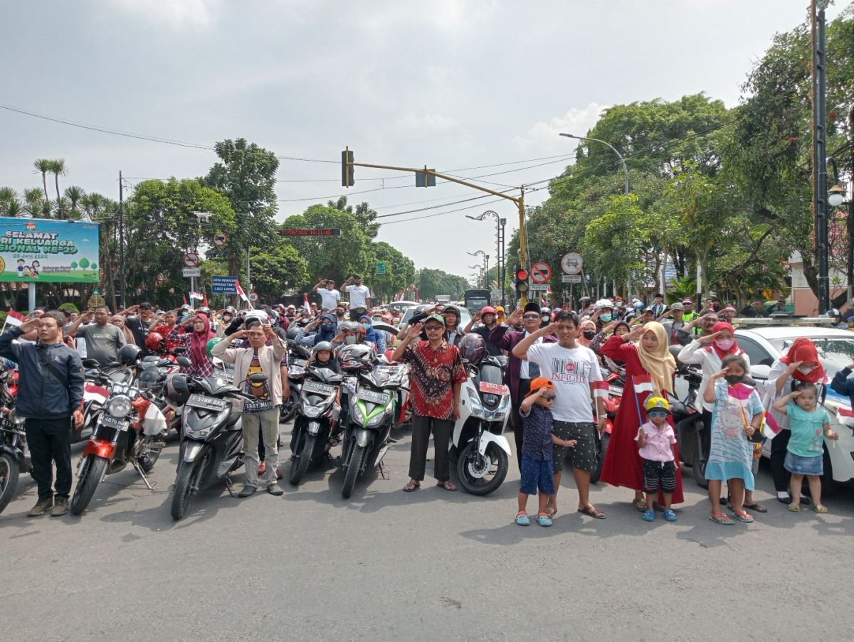 Ratusan warga dan pengguna jalan di jalur Nasional Surabaya-Madiun saat hormat Bendera Merah Putih saat detik-detik proklamasi.(Foto: Elok Aprianto)