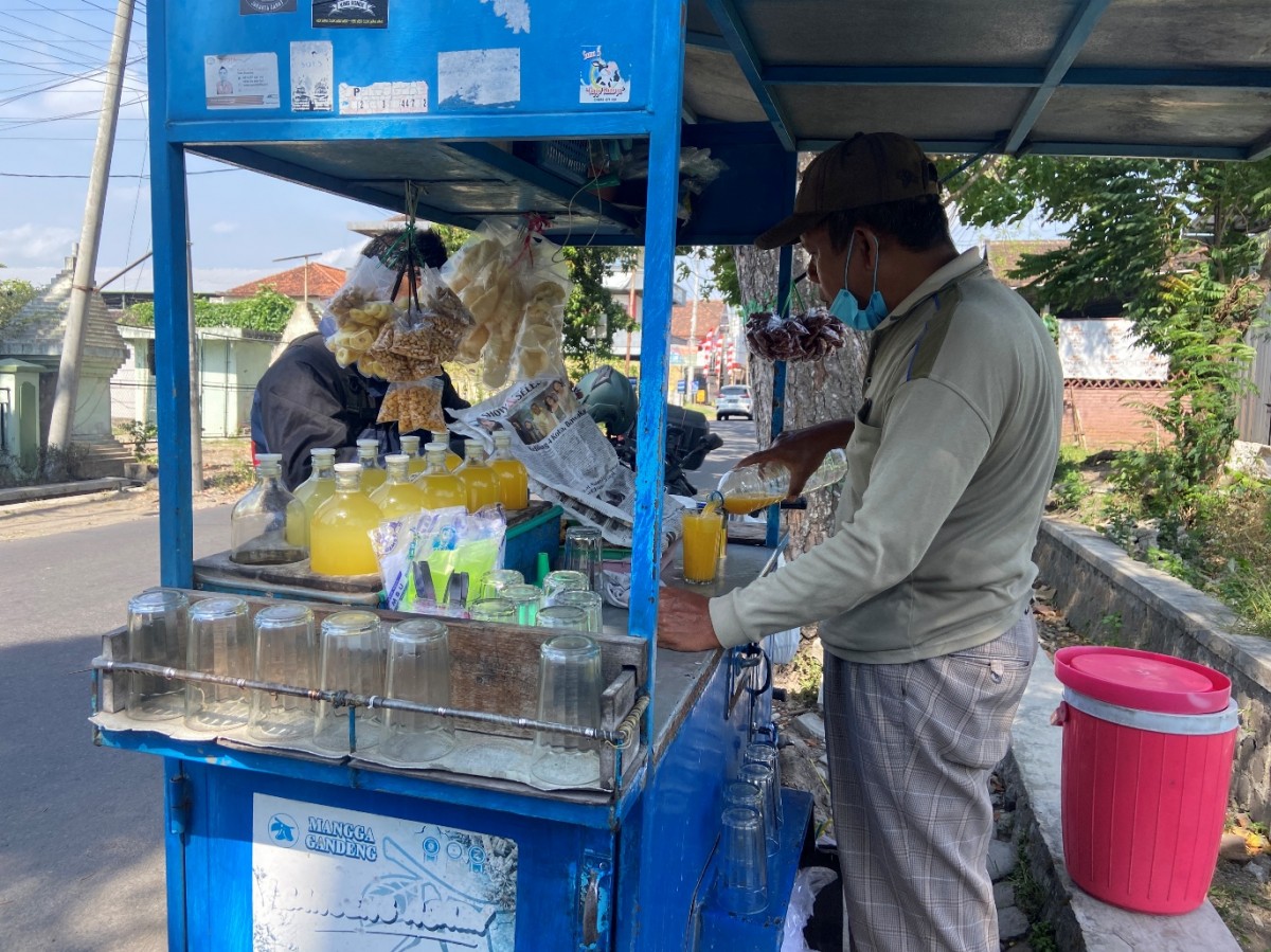 Nur tengah melayani pembeli es jamu.(Foto: Yanuar Dedy/jatimnow.com)