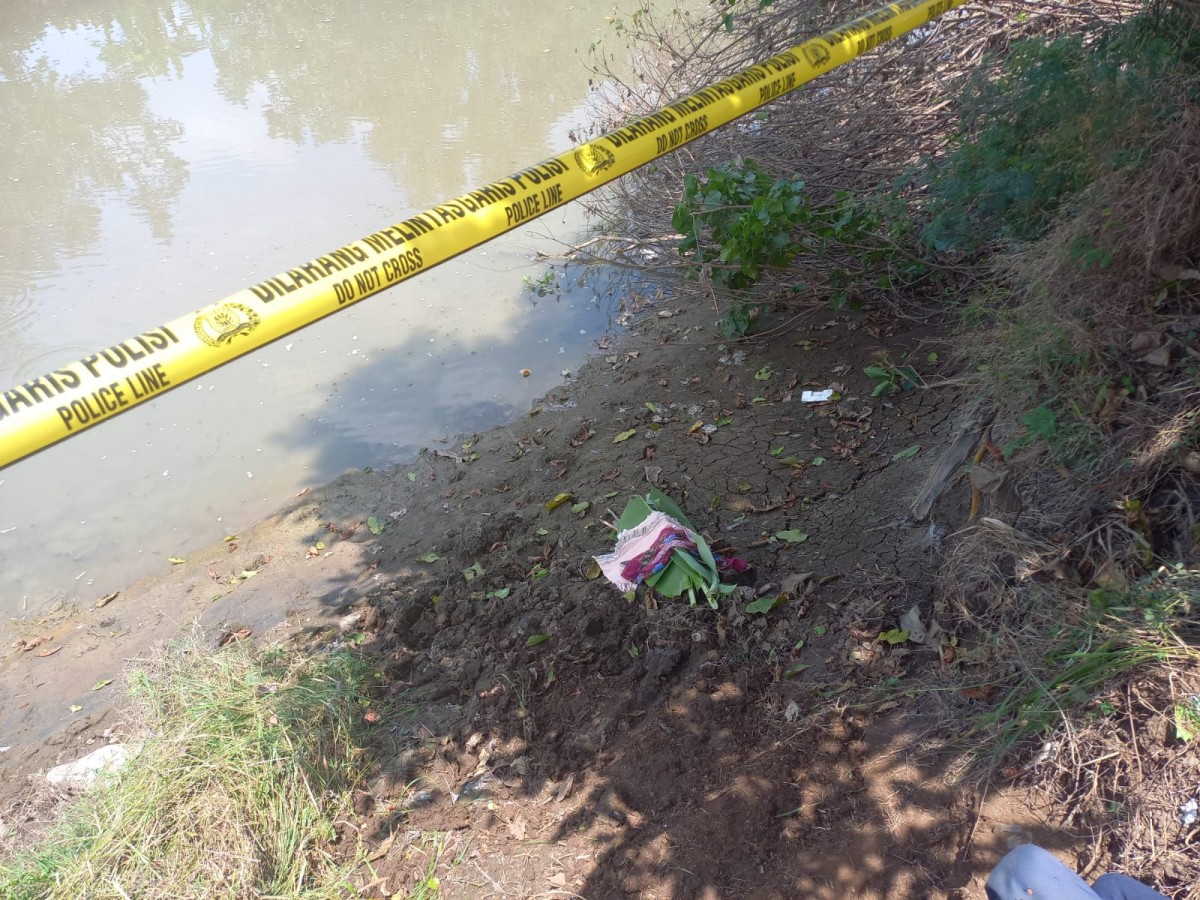 Mayat balita laki-laki yang ditemukan warga di tepi sungai Dusun Sidokampir, Desa Budugsidorejo, Kecamatan Sumobito.(Foto: Elok Aprianto/jatimnow.com)