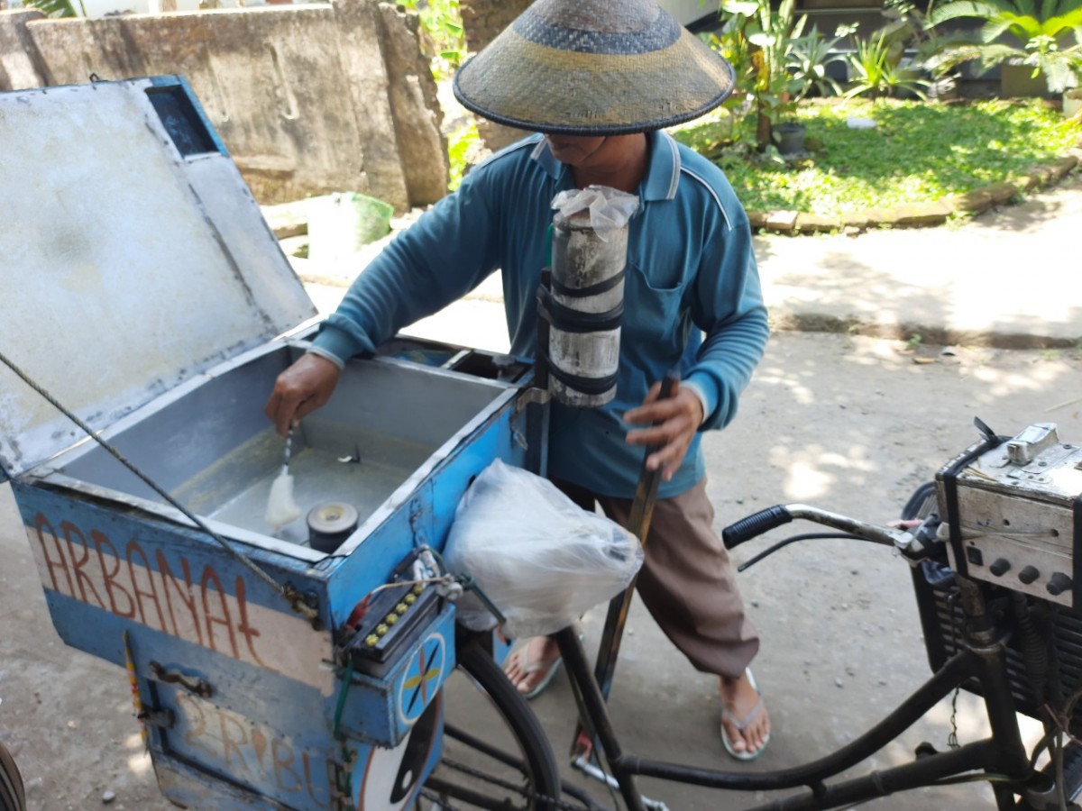 Ilyas, pedagang jajanan jadul yang masih setia berjualan arbanat. (Foto: Elok Apriyanto/jatimnow.com)
