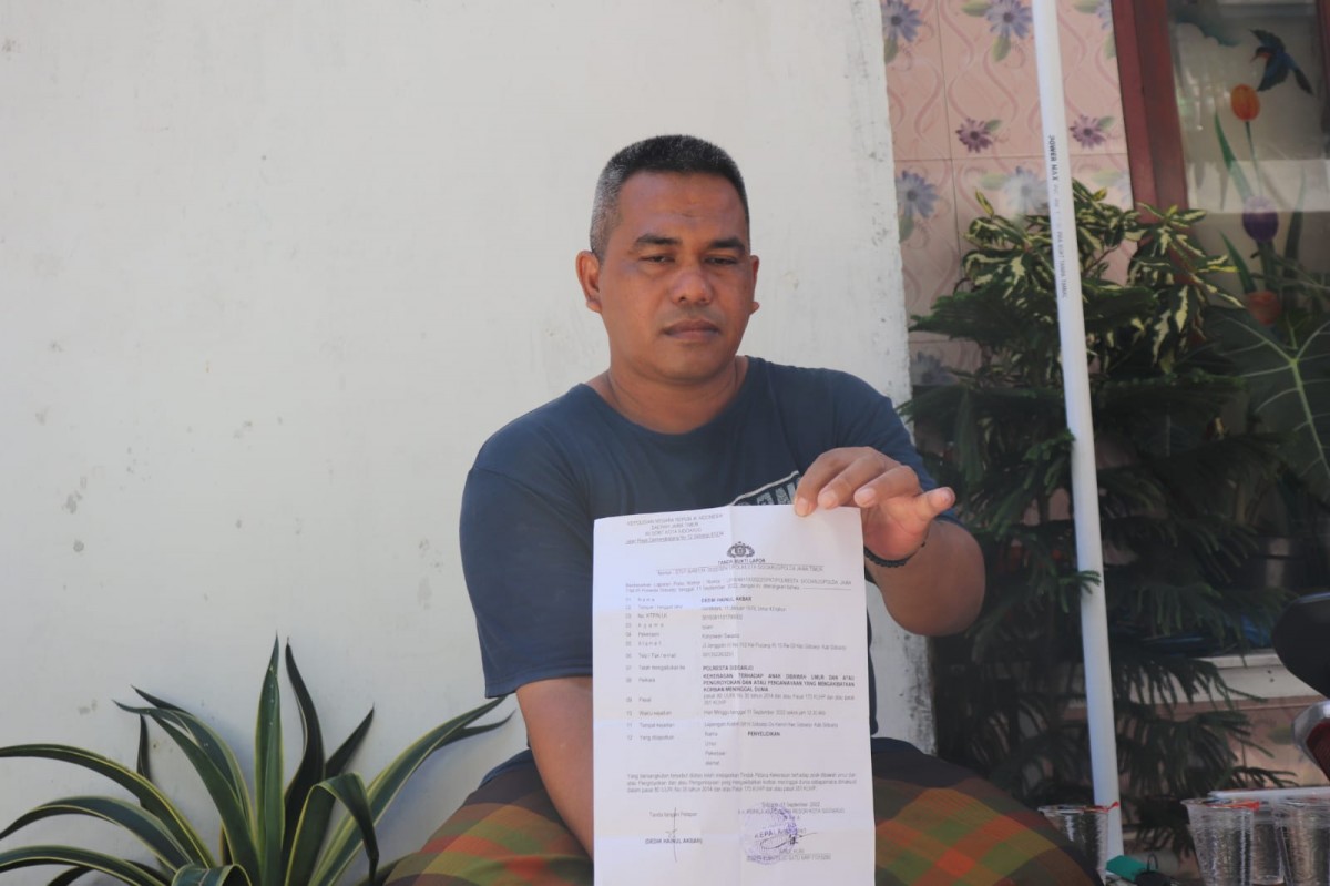 Orang tua Alif saat menunjukkan bukti laporan ke Polresta Sidoarjo.  (Foto: Zainul Fajar/jatimnow.com)