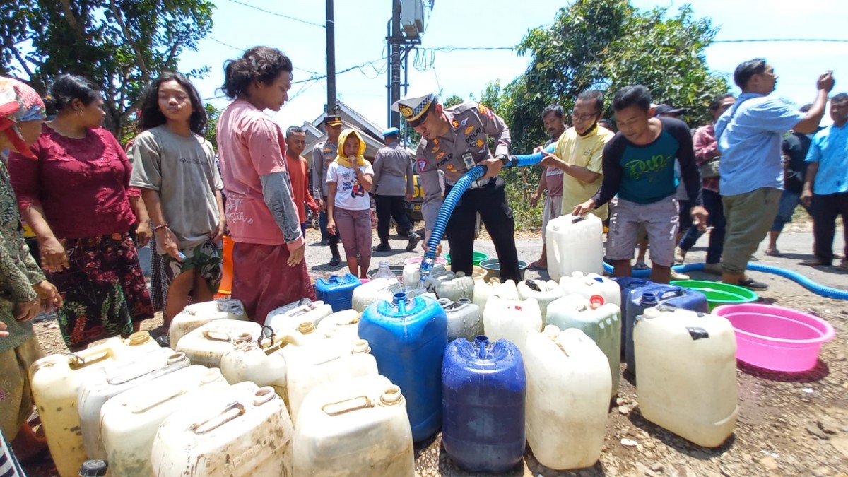 Kapolres Pasuruan, AKBP Bayu Pratama Gabunagi saat menyalurkan air bersih. (Foto: Moch. Rois/jatimnow.com)