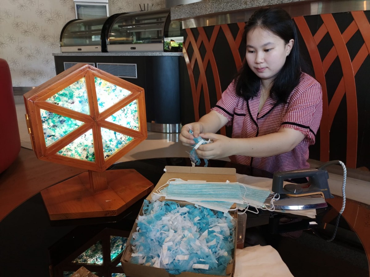 Olivia Tantiono saat menunjukkan serpihan masker yang telah dicuci dan dijemur, siap untuk proses press heat.(Foto: Ajeng for jatimnow.com)