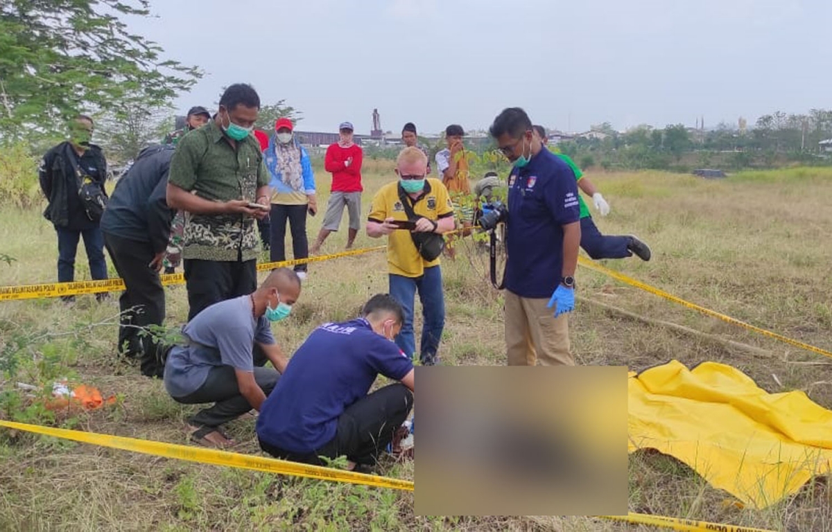 Polisi melakukan olah TKP temuan mayat di tanah lapang Lamongan. (Foto: Humas Polres Lamongan for jatimnow.com)