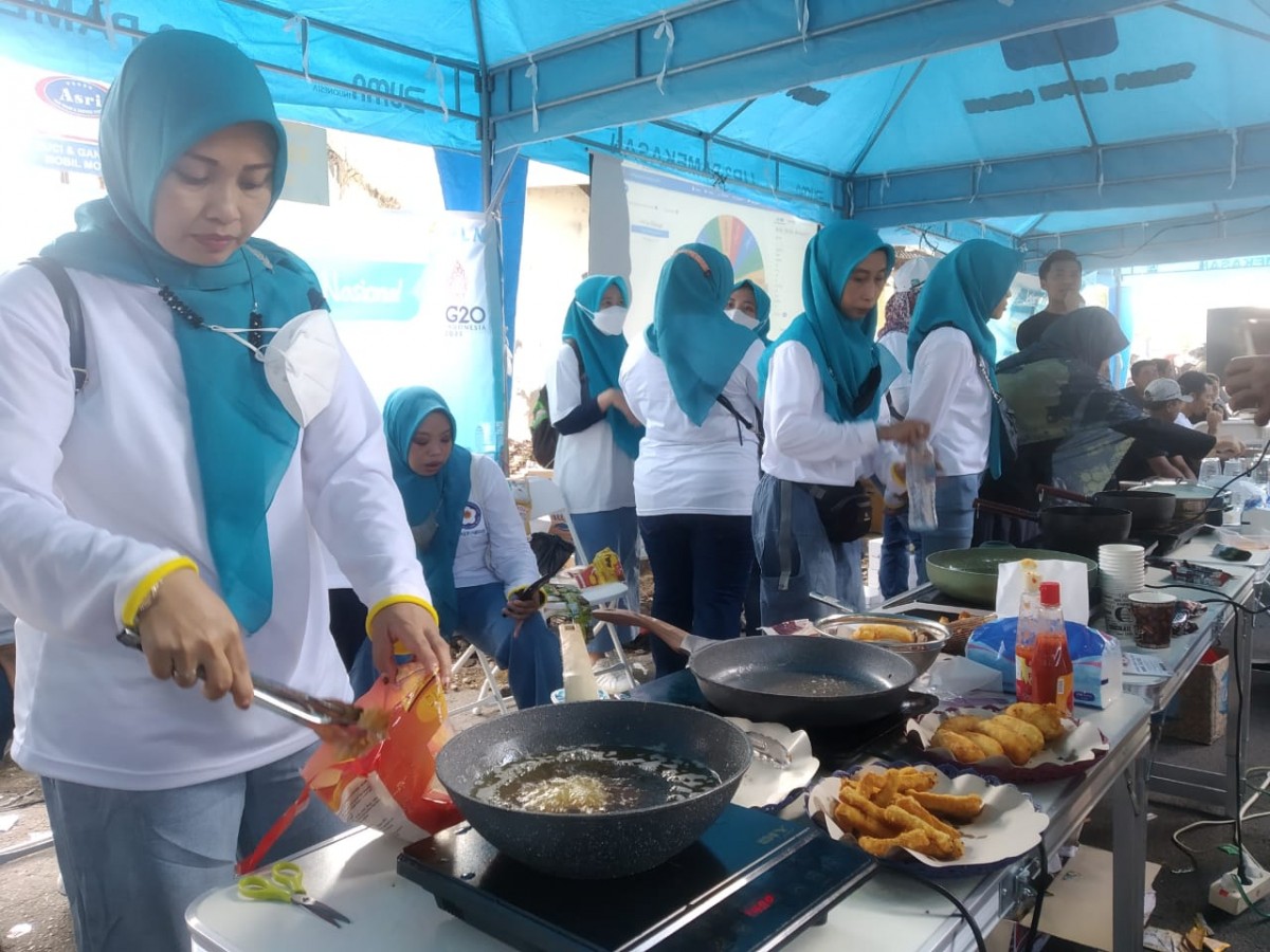 PLN memperkenalkan penggunaan kompor induksi dalam rangka Hari Pelanggan Nasional. (Foto: Fathor Rahman/jatimnow.com)