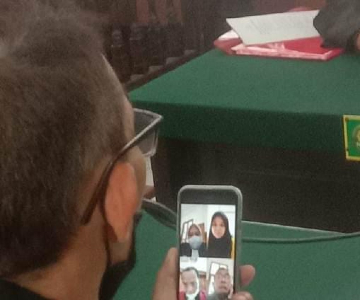 Prilly, terdakwa pembuang bayi di sungai Jemur Ngawinan, Surabaya, saat mengikuti sidang melalui teleconference. (Foto: Zain Ahmad/jatimnow.com)