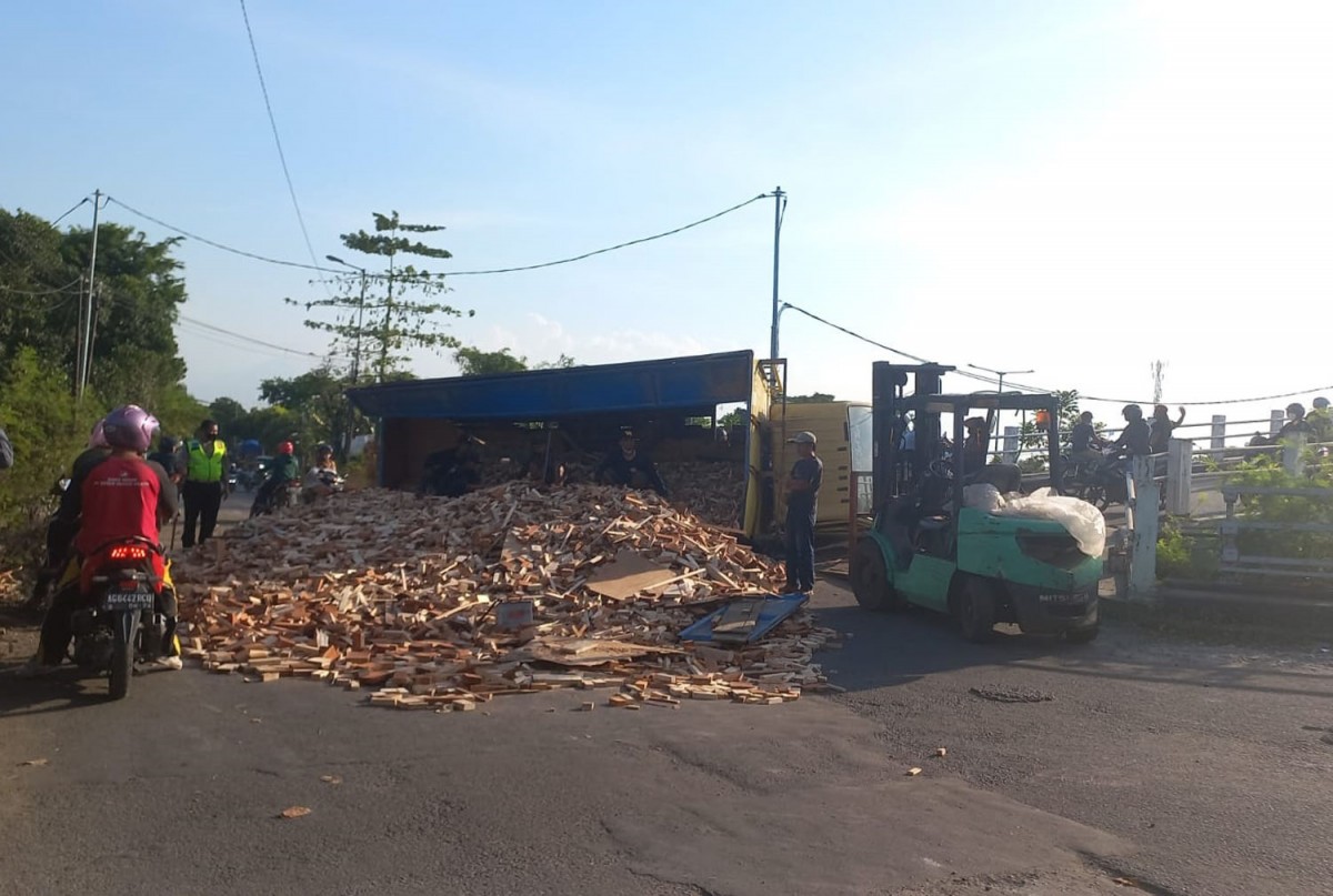Truk bermuatan kayu potongan terguling di Sidoarjo (Foto: Unit Gakkum Polresta Sidoarjo for jatimnow.com)