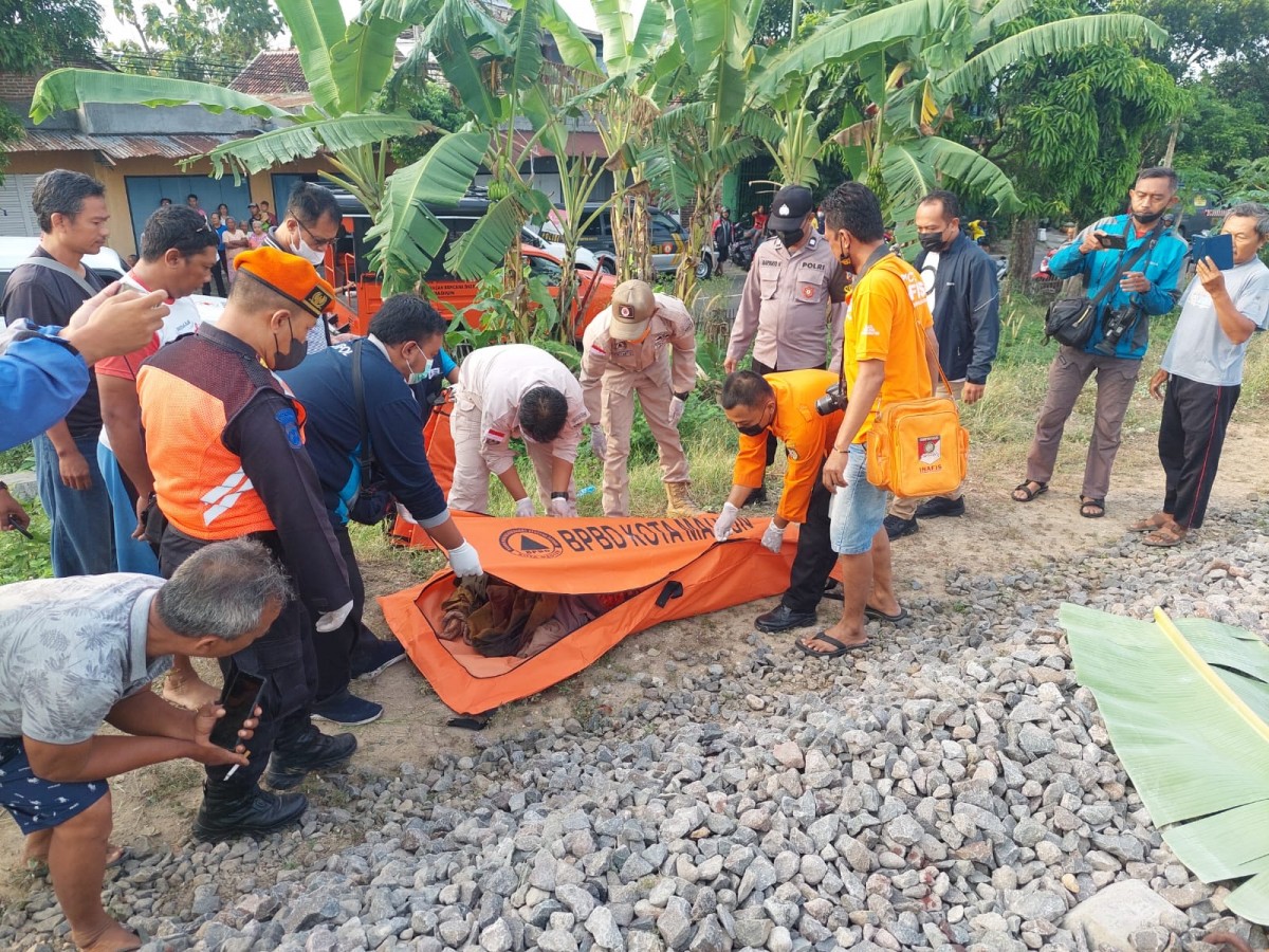 Petugas melakukan evakuasi korban tertabrak kereta api. (Foto: Polsek Kartoharjo)