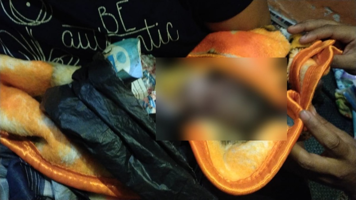 Bayi laki-laki yang ditemukan di depan kos saat dievakuasi petugas dan warga.(Foto: Polsek Karangpilang/jatimnow.com)