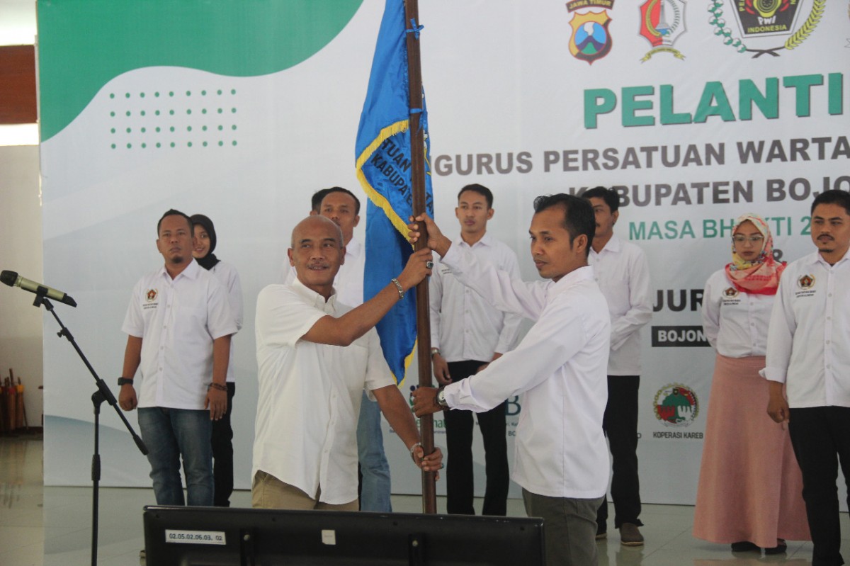 Wakil Ketua Bidang Organisasi PWI Jatim Machmud Suhermono secara simbolis menyerahkan pataka bendera PWI kepada M Yazid Ketua PWI Bojonegoro (Foto: Misbahul Munir/jatimnow.com)