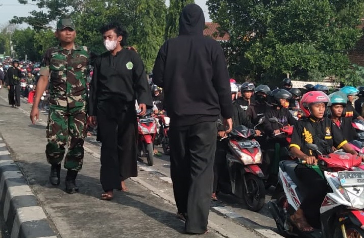 Ribuan massa pesilat saat melintas dan mendapat serangan di Jalan Nasional Lamongan - Babat. (Foto: Adyad Ammy Iffansah/jatimnow.com)