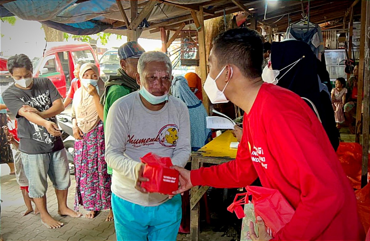 Petugas Binda Jatim saat membagikan bantuan paket vitamin kepada warga Gresiik. (Foto: Sahlul Fahmi/jatimnow.com)
