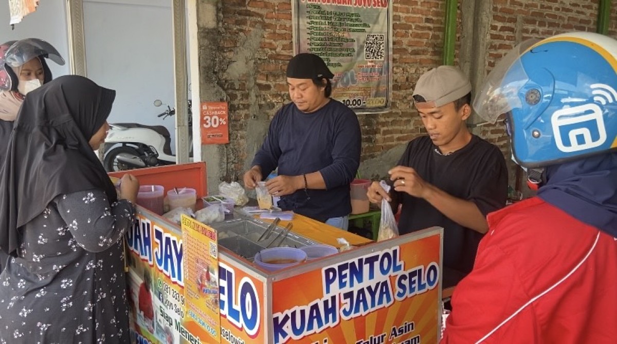 Andris Tri Widodo dibantu karyawannya saat melayani pembeli (Foto-foto: Mita Kusuma/jatimnow.com)