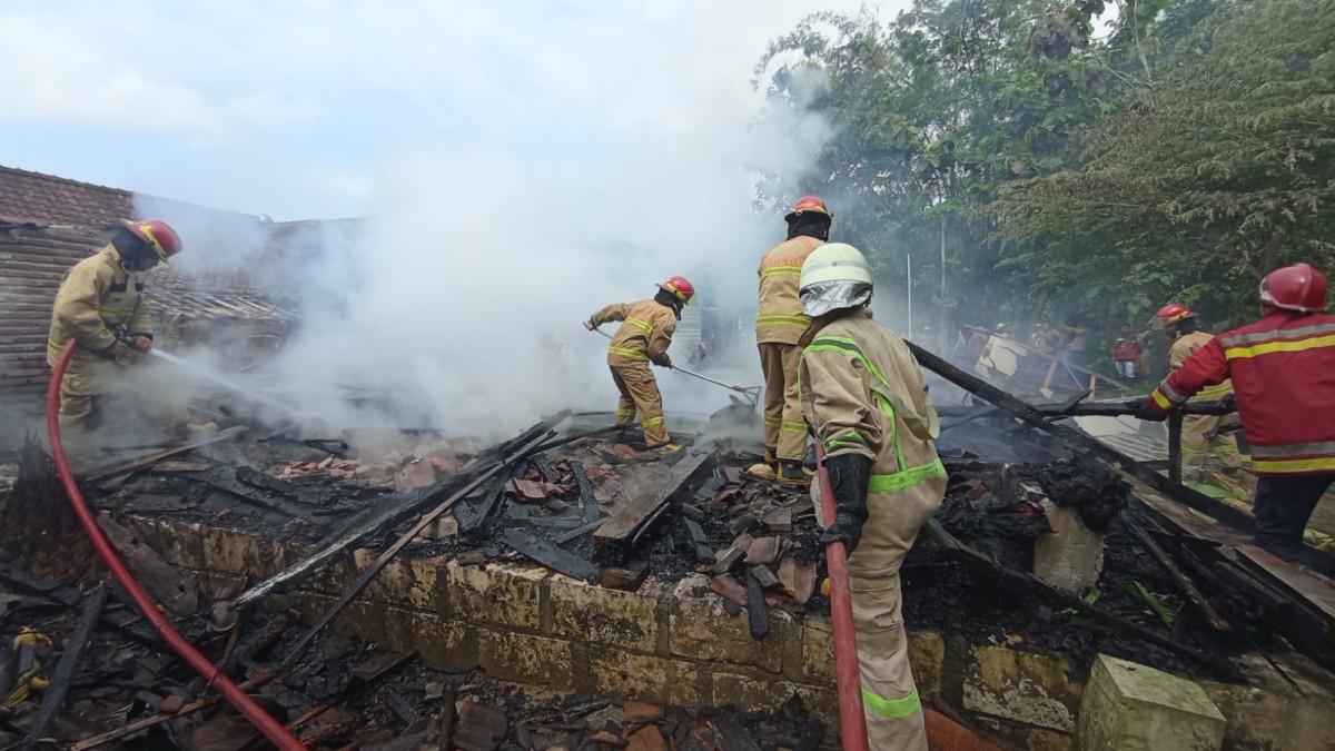 Proses pemadaman tempat oven tembakau di Temayang.(Foto: Misbahul Munir/jatimnow.com)