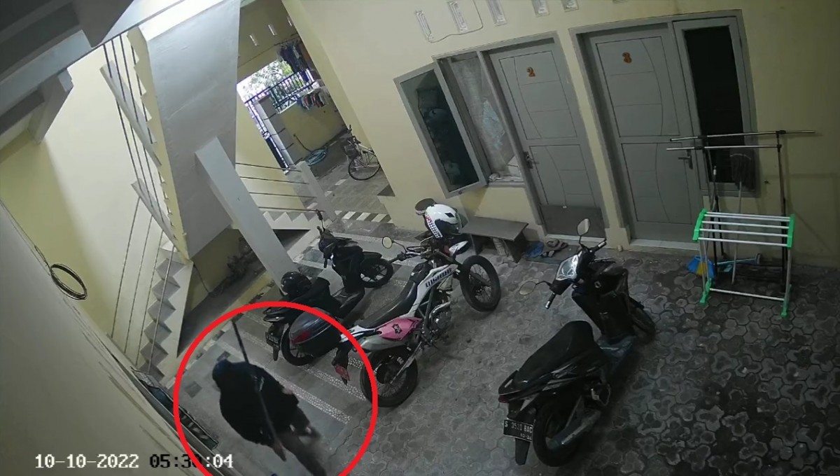 Pelaku saat terekam CCTV masuk ke kos berjalan pincang dengan membawa tongkat kayu. (Foto: Tangkapan layar video CCTV)